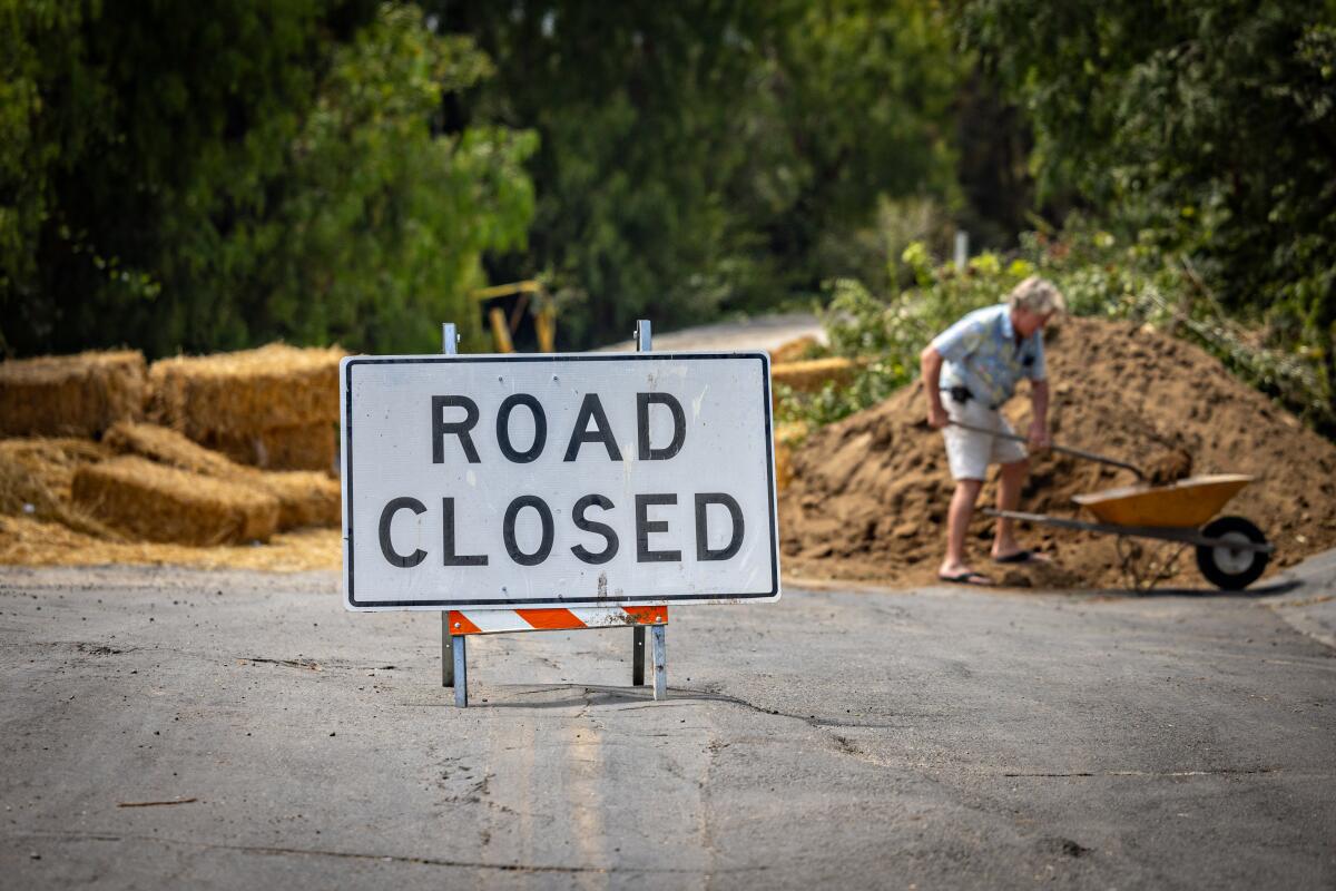 A closed road, with a pile of dirt from a landslide.