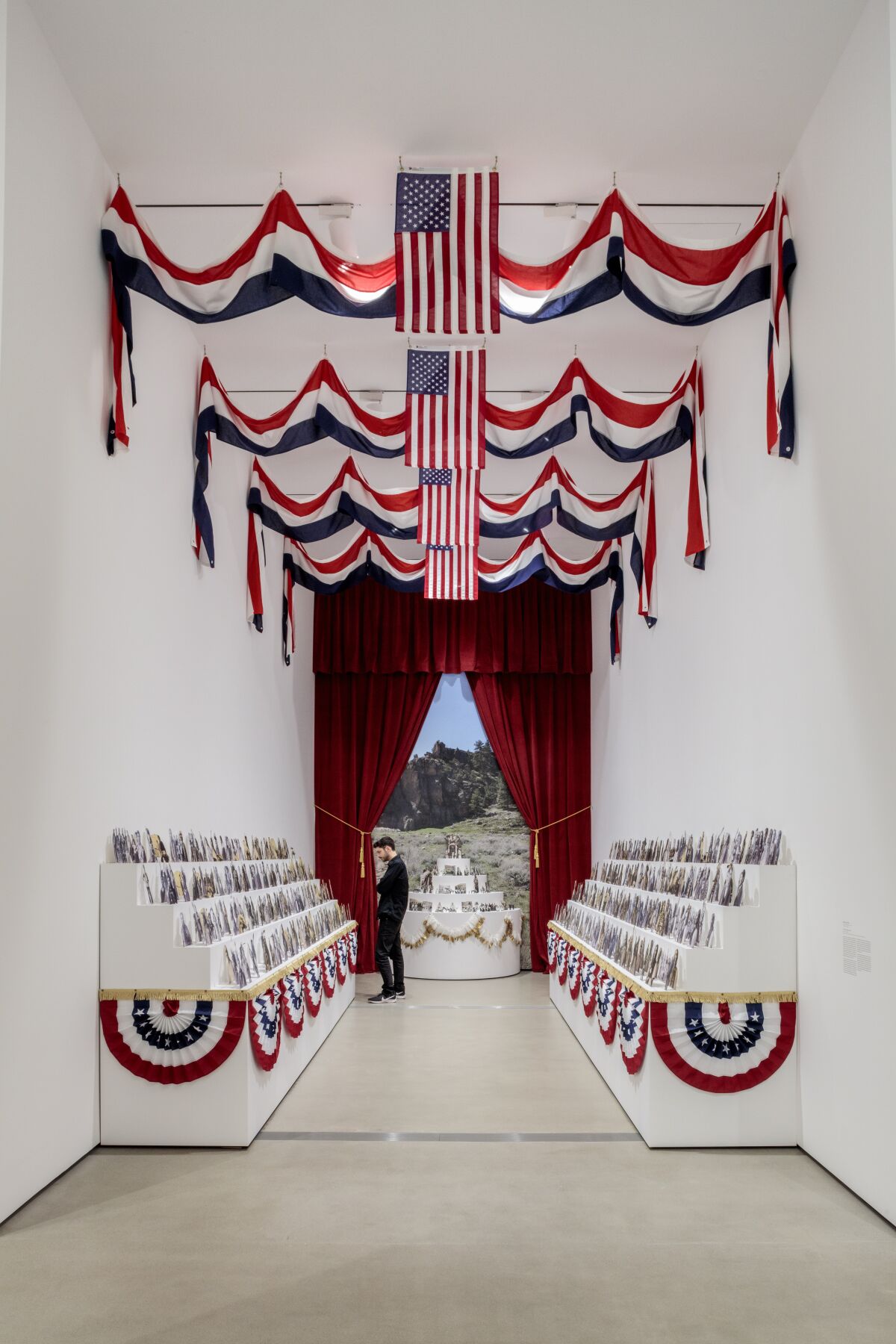 Flags and red, white and blue bunting decorate an alcove with rows of photos.