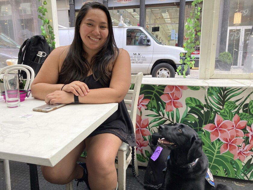 Mary Tardif, of Manhattan, sits with her service dog, Daisy, Friday, July 1, 2022, in New York, after a Manhattan federal court jury awarded her $431,250 after finding in her favor in a lawsuit she brought against New York City and its police department for injuries she suffered when she served as a medic for protesters at Occupy Wall Street events in 2012. (AP Photo/Larry Neumeister)