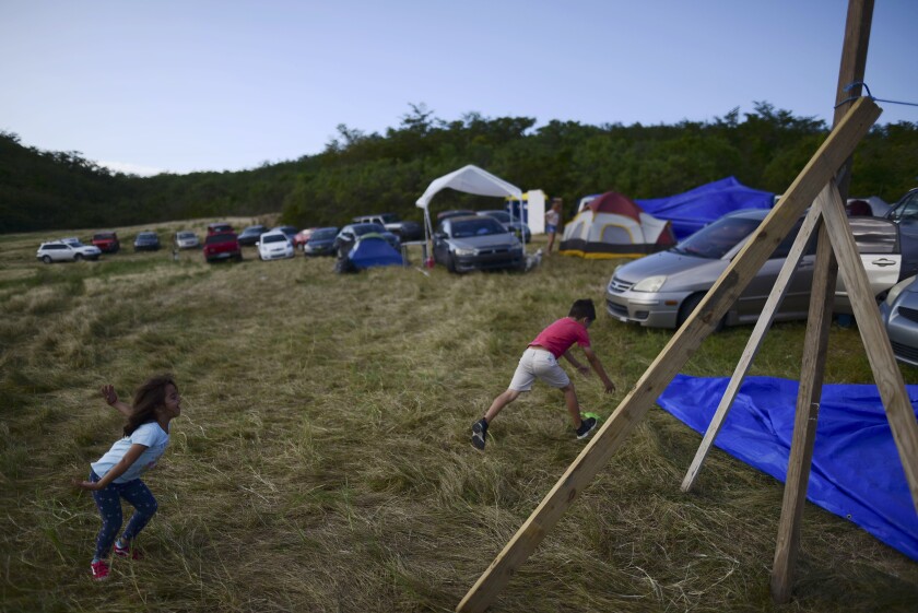 Children play on a hay farm where residents from the Indios neighborhood of Guayanilla, Puerto Rico, have set up shelter after earthquakes on  Jan. 10.