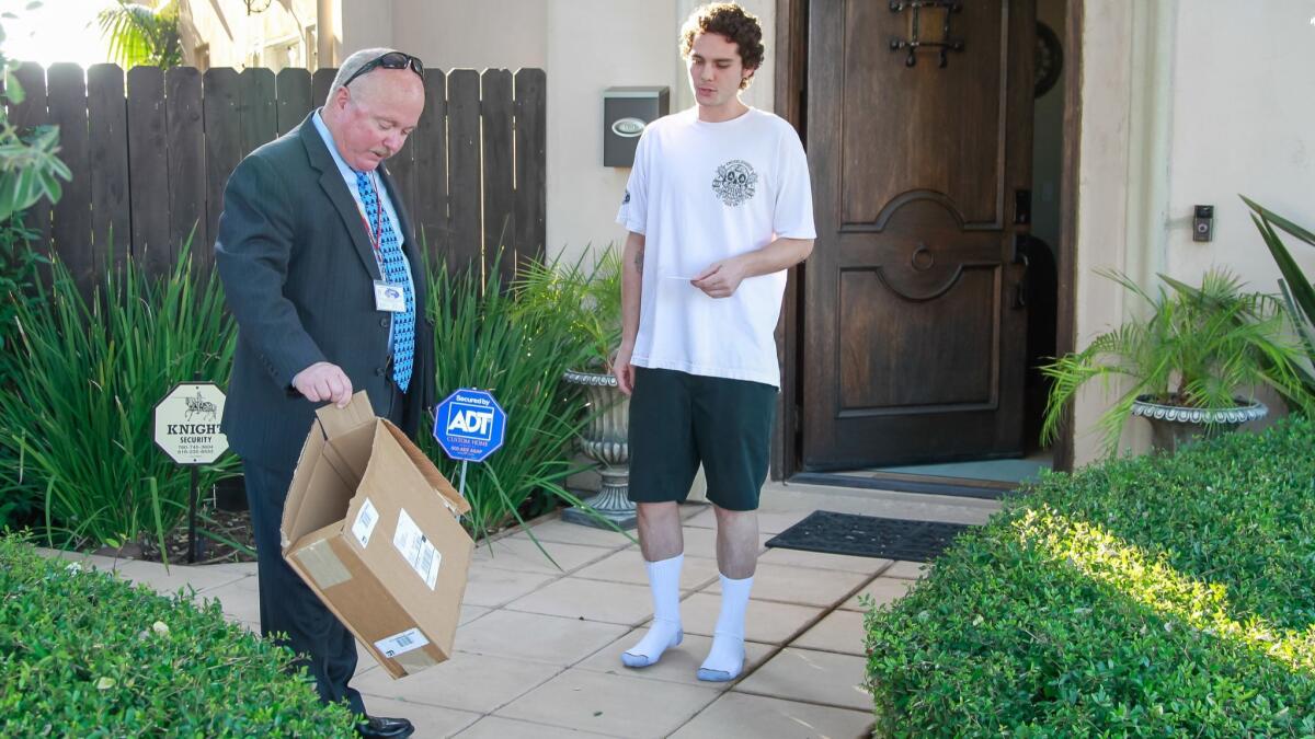 Oceanside Police Department Sgt. John McKean (left) talks to Korbin Morgan whose Ring doorbell caught a person stealing a package from his home on Tuesday in Oceanside. Morgan posted the video and McKean was following up with an investigation of the crime.