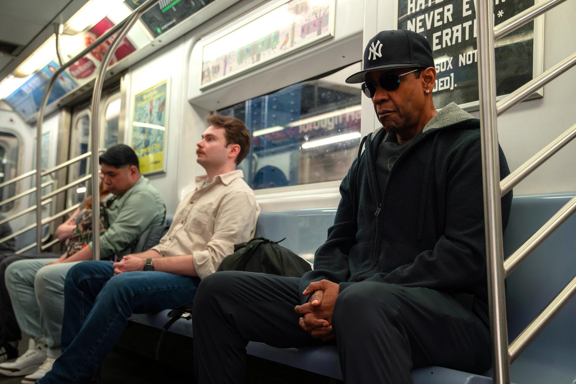 A man in a Yankees cap rides the subway incognito.