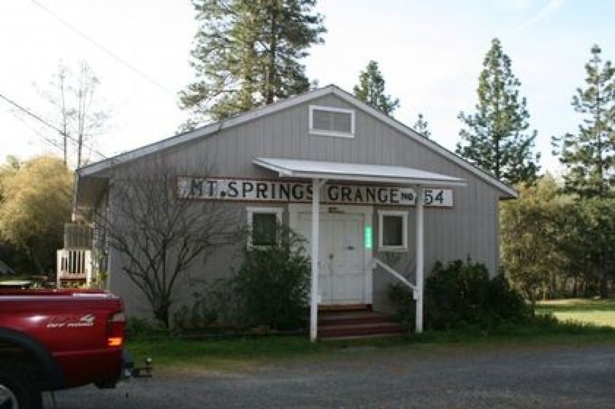 A gray building with the sign "Mt. Springs Grange #754"