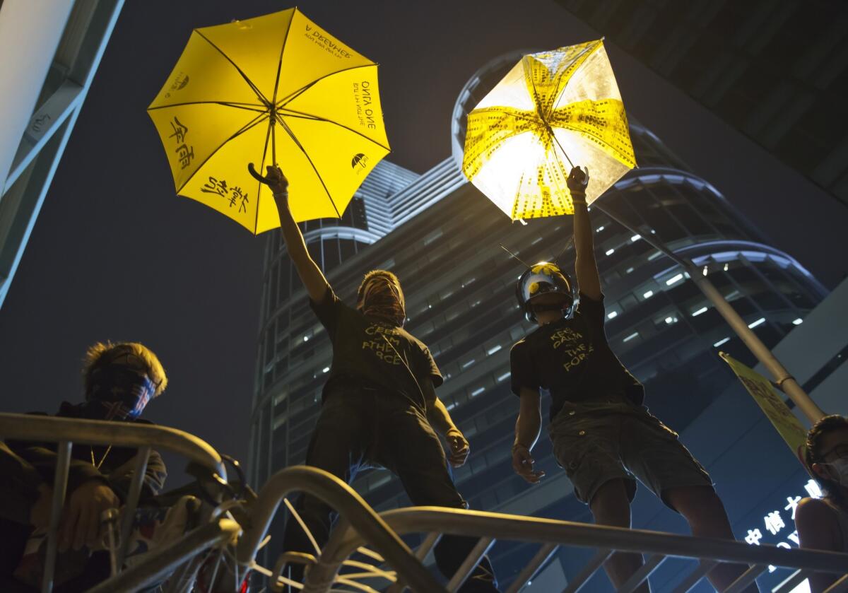 Pro-democracy activists pose for photographs on a barricade outside the government headquarters in Hong Kong on Dec. 10.