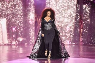 Tyra Banks walks the runway during the Victoria's Secret Fashion Show in a bustier, leggings and a cape