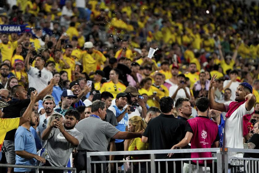 Uruguay's Ronald Araujo, right, argues with fans at the end of a Copa America semifinal soccer match against Colombia, Wednesday, July 10, 2024, in Charlotte, N.C. (AP Photo/Julia Nikhinson)