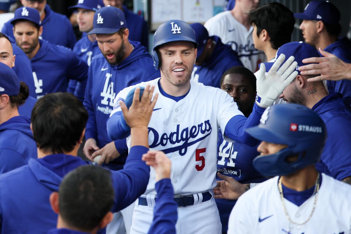 Dodgers first baseman Freddie Freeman celebrates in the dugout after scoring a run in Game 1 of the NLCS.