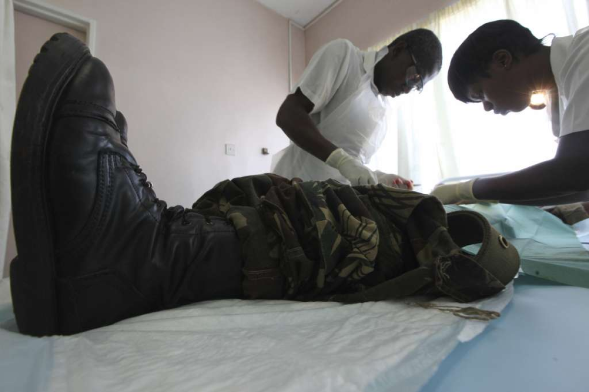 The health benefits of circumcision outweigh the risks, the CDC says in new draft guidelines issued Dec. 2. Much of the evidence is based on studies in Africa. Above, a doctor and nurse perform a circumcision on a soldier in Harare, Zimbabwe.