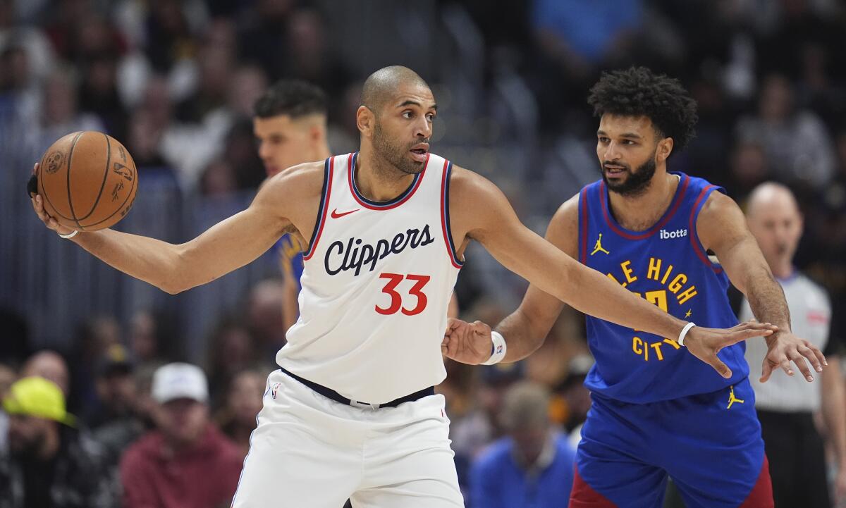 Clippers forward Nicolas Batum looks to pass the ball as Denver Nuggets guard Jamal Murray defends