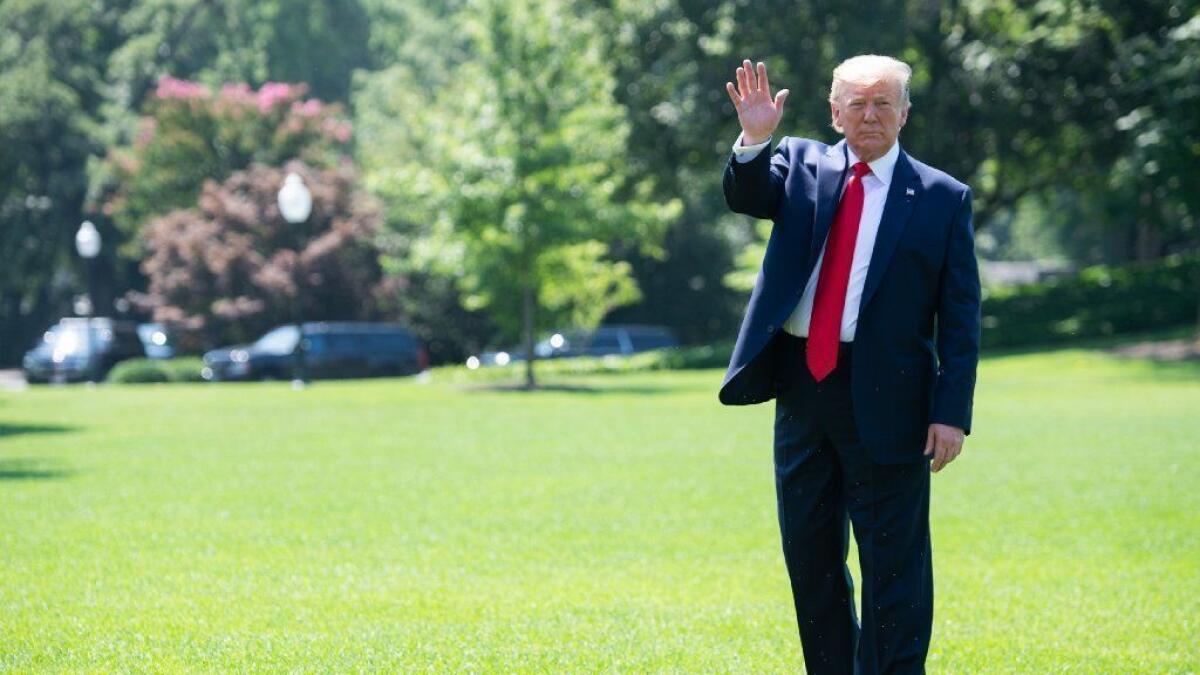 President Trump waves to the media as he walks to Marine One before departing from the South Lawn of the White House on Friday.