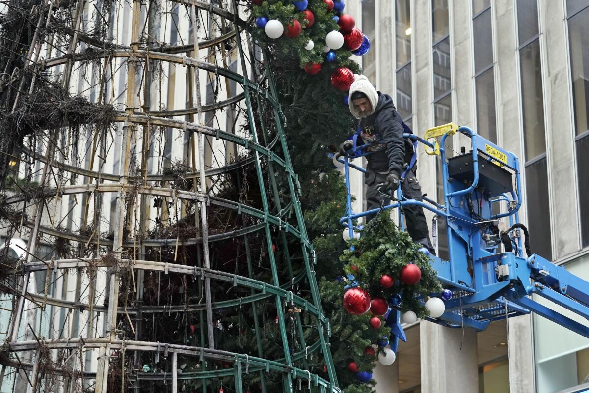 Un trabajador desmonta un árbol de Navidad frente a la sede de Fox News en Nueva York el miércoles 8 de diciembre de 2021. 