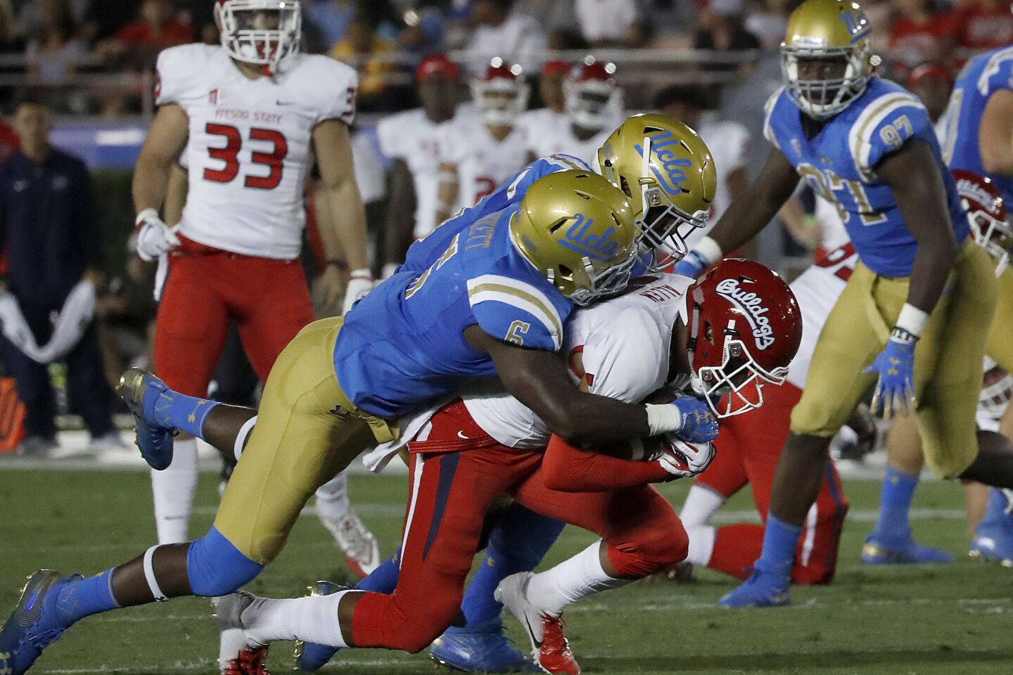 UCLA defenders Adarius Pickett (6) and Krys Barnes bring down Fresno State wide receiver Justin Allen in the second quarter on Saturday at the Rose Bowl.