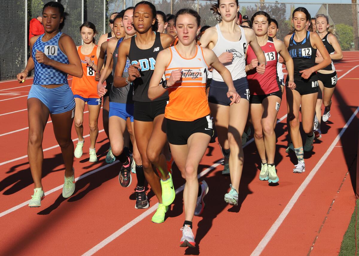 Huntington Beach's Makenzie McRae, center, and Corona del Mar's Melisse Djomby-Enyawe, left, compete Saturday.