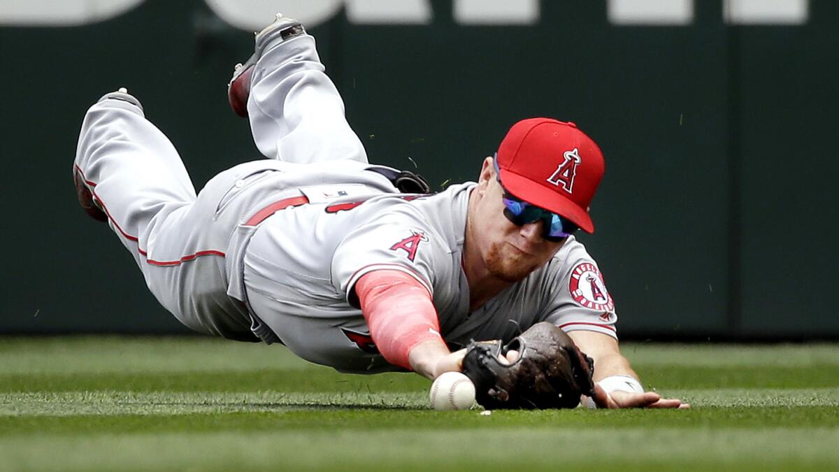 Angels right fielder Kole Calhoun comes up short on a diving attempt to catch a hit by Seattle's Nelson Cruz during the fourth inning Sunday.