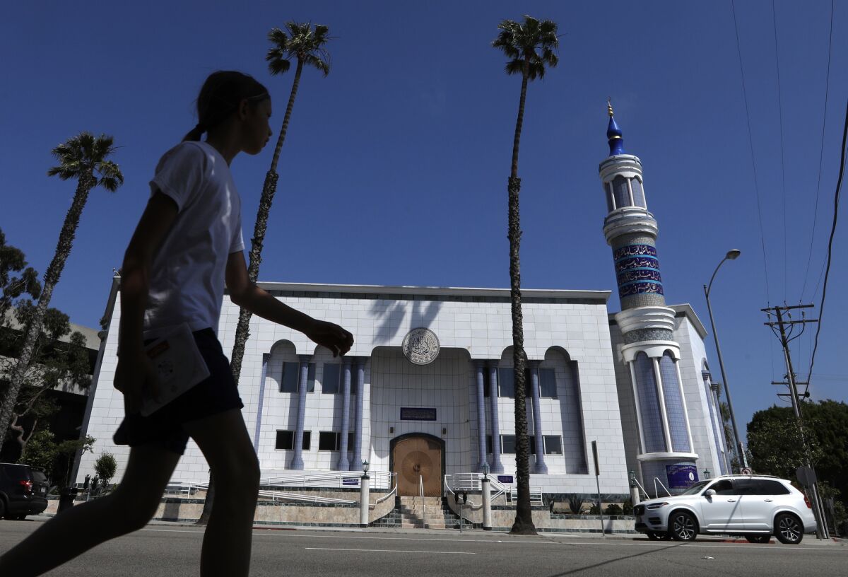 A pedestrian walks across the street from the King Fahad Mosque, which anchors the neighborhood along Washington Boulevard in Culver City.