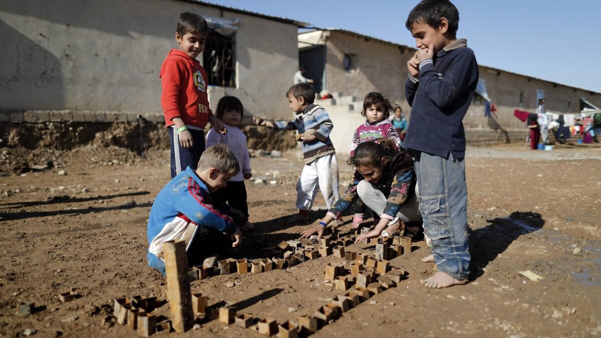 Displaced Iraqi children, who fled the violence in the northern city of Mosul play on Dec. 3, 2016, at the Hasan Sham refugee camp in Iraq.