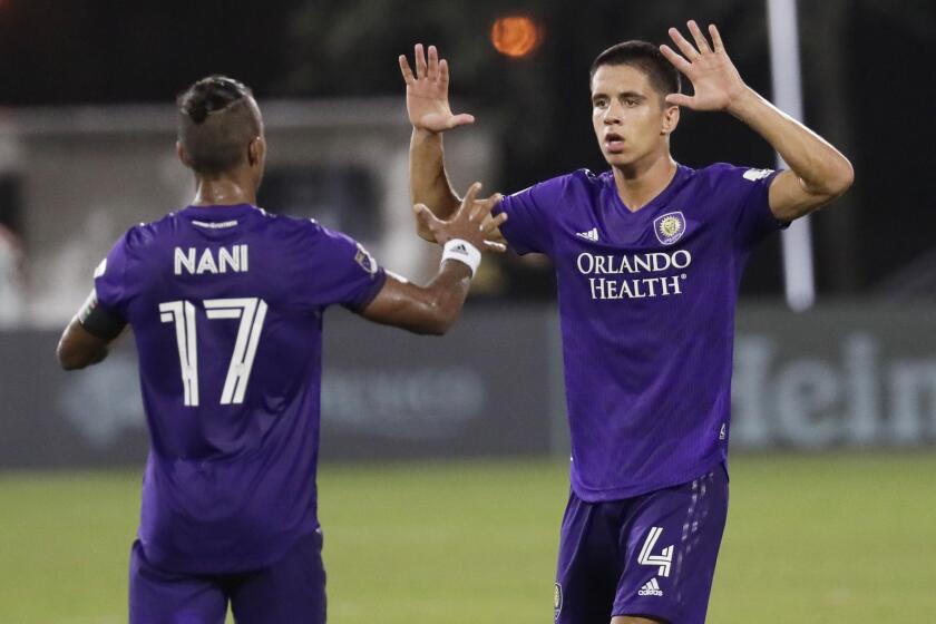 Orlando City defender Joao Moutinho (4) celebrates a goal with teammate Orlando City forward Nani (17) during the second half of an MLS soccer match, Friday, July 31, 2020, in Orlando, Fla. (AP Photo/John Raoux)