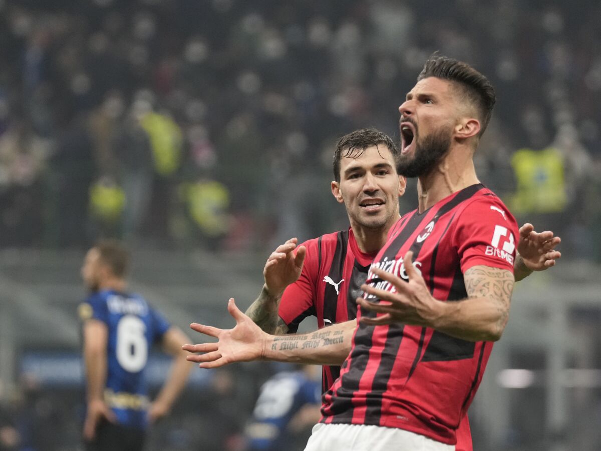 AC Milan's Olivier Giroud, front, celebrates with AC Milan's Alessio Romagnoli after scoring his side's opening goal during the Serie A soccer match between Inter Milan and AC Milan at the San Siro Stadium, in Milan, Italy, Saturday, Feb. 5, 2022. (AP Photo/Antonio Calanni)