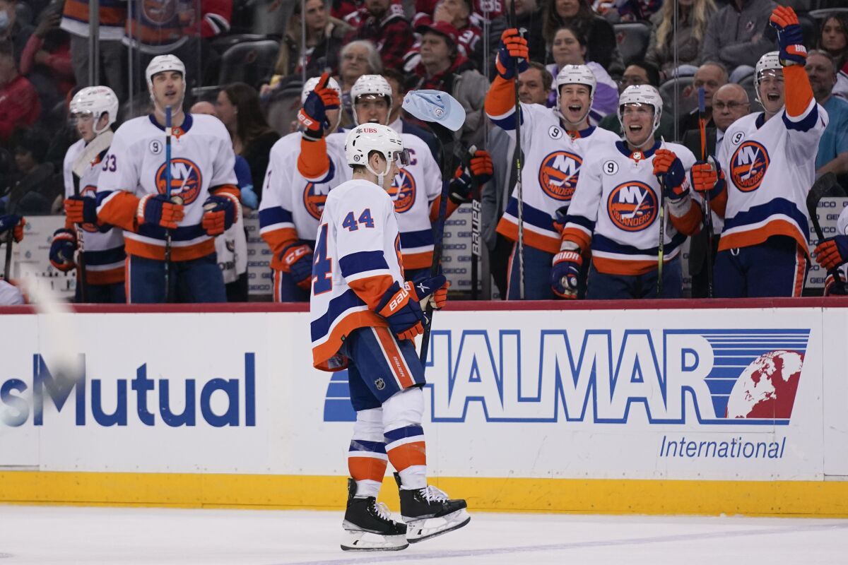 New York Islanders' Jean-Gabriel Pageau (44), center, carries a hat on his stick to celebrate his hat trick during the second period of the team's NHL hockey game against the New Jersey Devils in Newark, N.J., Sunday, April 3, 2022. (AP Photo/Seth Wenig)
