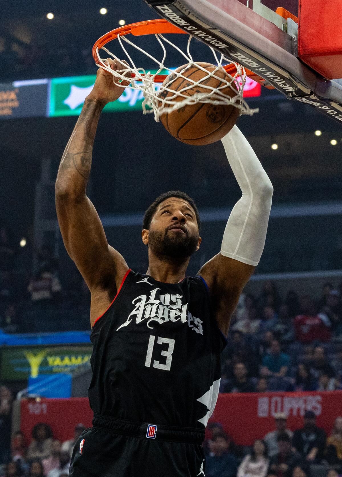 Clippers forward Paul George dunks against the Pistons in the first quarter Saturday.
