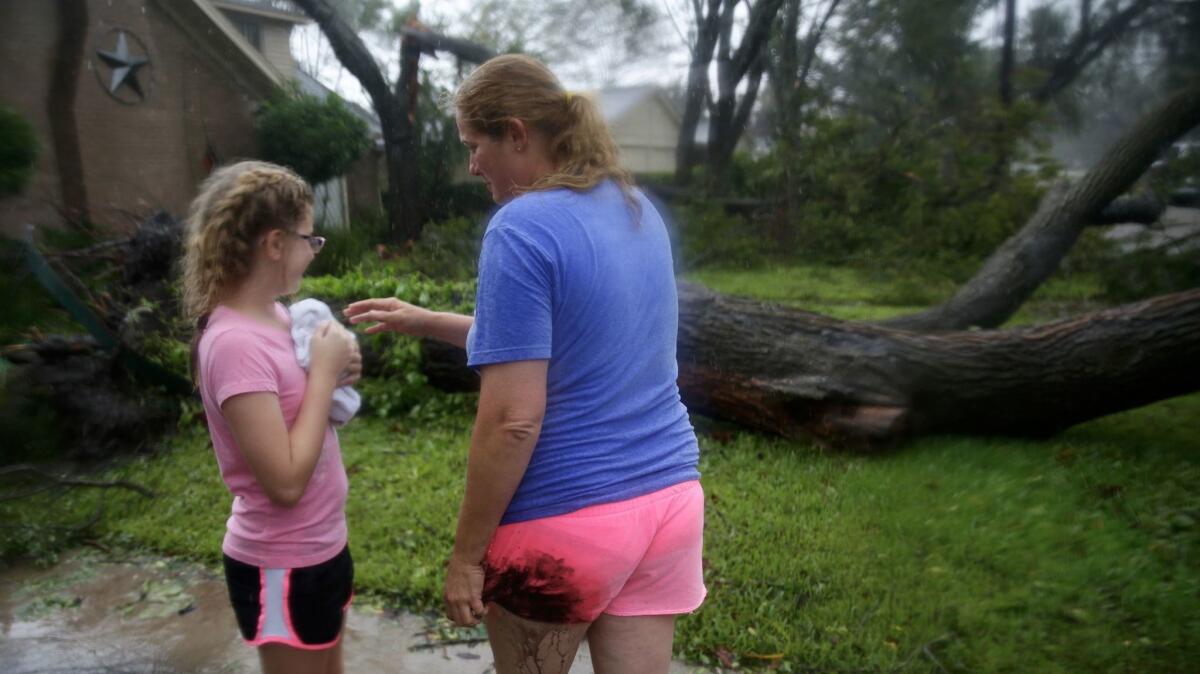 Nancy Bram, 39, watches her daughter Addyson Hilgart, 10, cuddle an orphaned squirrel they named Harvey as Hurricane Harvey passes over Victoria, Texas.