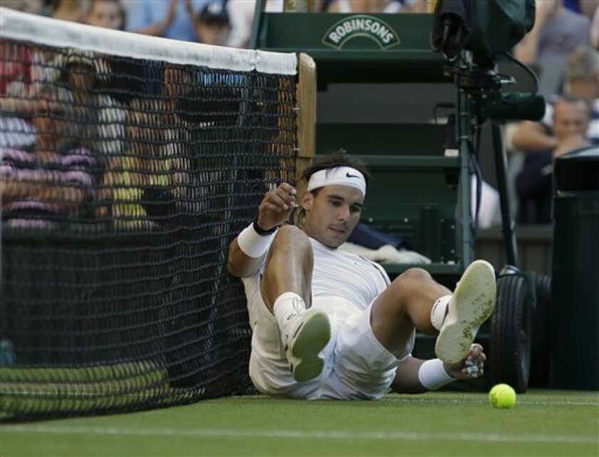 Rafael Nadal of Spain lies on the court after failing to return a shot to Lukas Rosol of the Czech Republic during a second round men's singles match at the All England Lawn Tennis Championships at Wimbledon, England, Thursday, June 28, 2012. (AP Photo/Anja Niedringhaus)