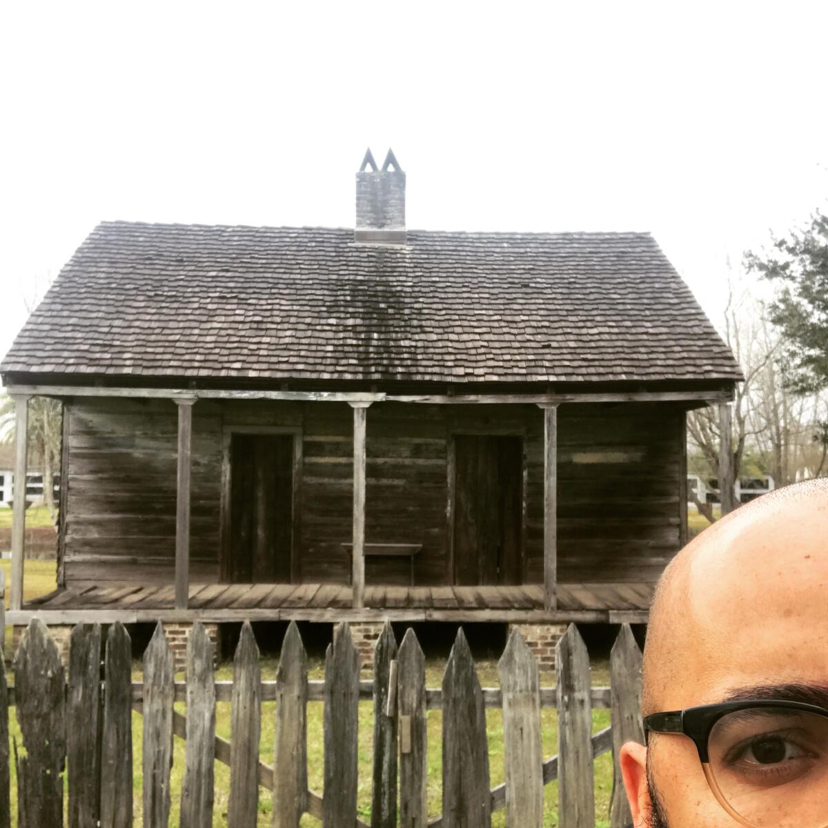 Clint Smith stands in front of an original slave cabin at the Whitney Plantation in New Orleans.