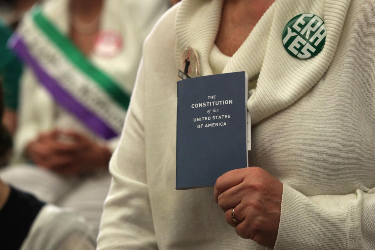 An activist holds a copy of the U.S. Constitution during a news conference on women's rights in April on Capitol Hill in Washington.