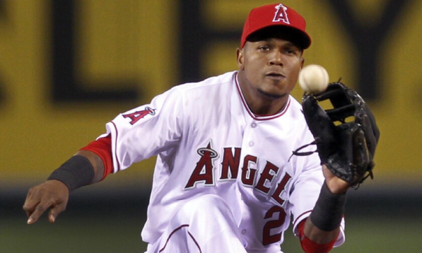 Angels shortstop Erick Aybar makes a catch before tagging out Seattle's Justin Smoak at second base during the Angels' loss Tuesday. The Angels have taken a new-age approach when it comes to the positioning of players against certain batters.