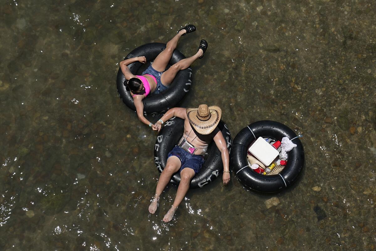 Two people float in inner tubes on a river.