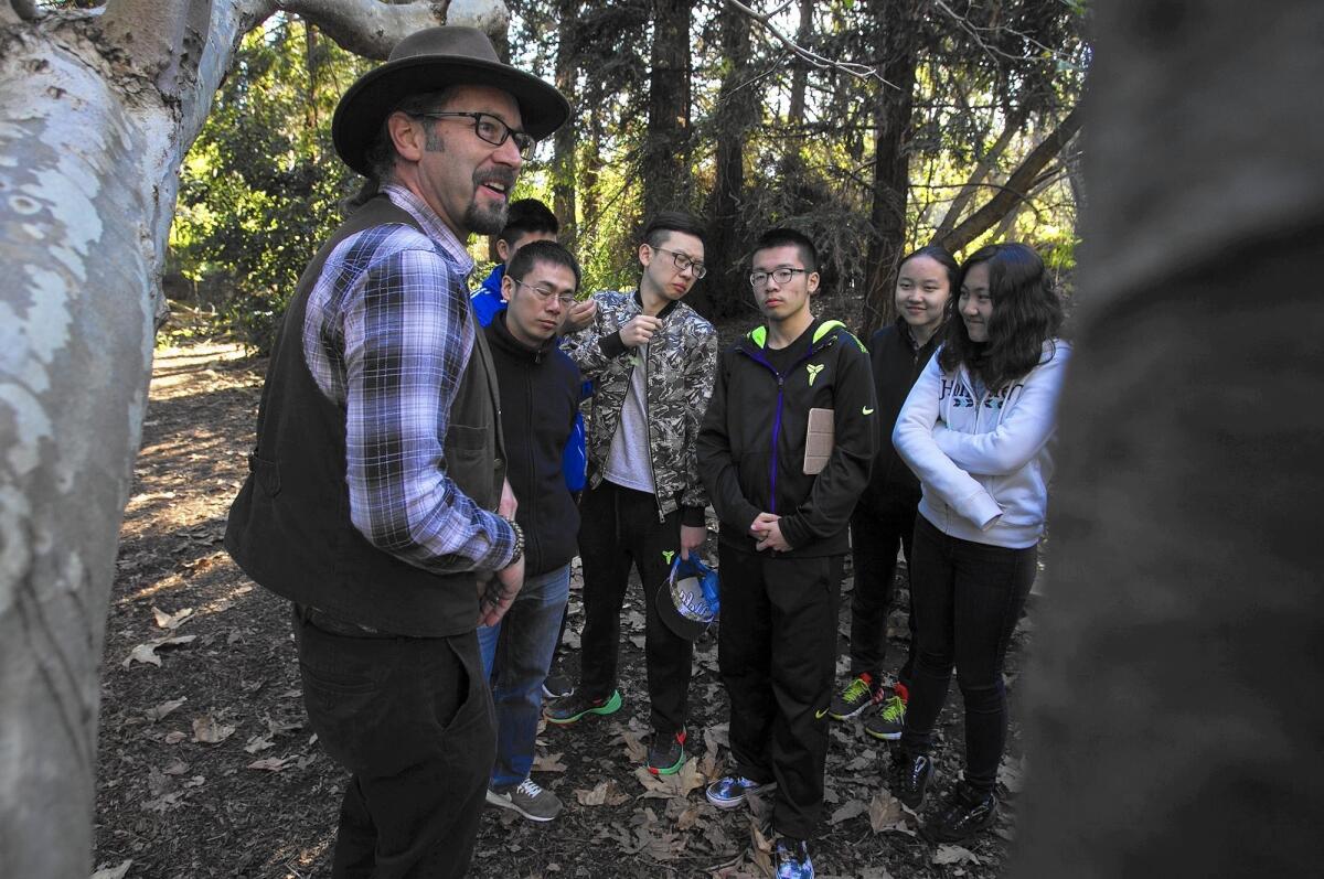 Bo Glover, executive director of the Environmental Nature Center in Newport Beach, takes students from Experimental High School in Beijing on a tour of the grounds Wednesday.
