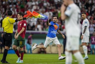 Un aficionado irrumpe en la cancha con la bandera arcoíris durante el partido del Grupo H entre Portugal y Uruguay, el lunes 28 de noviembre de 2022, en Lusail, Qatar. (AP Foto/Abbie Parr)
