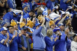 Detroit Lions fans cheer during a game against the Green Bay Packers.
