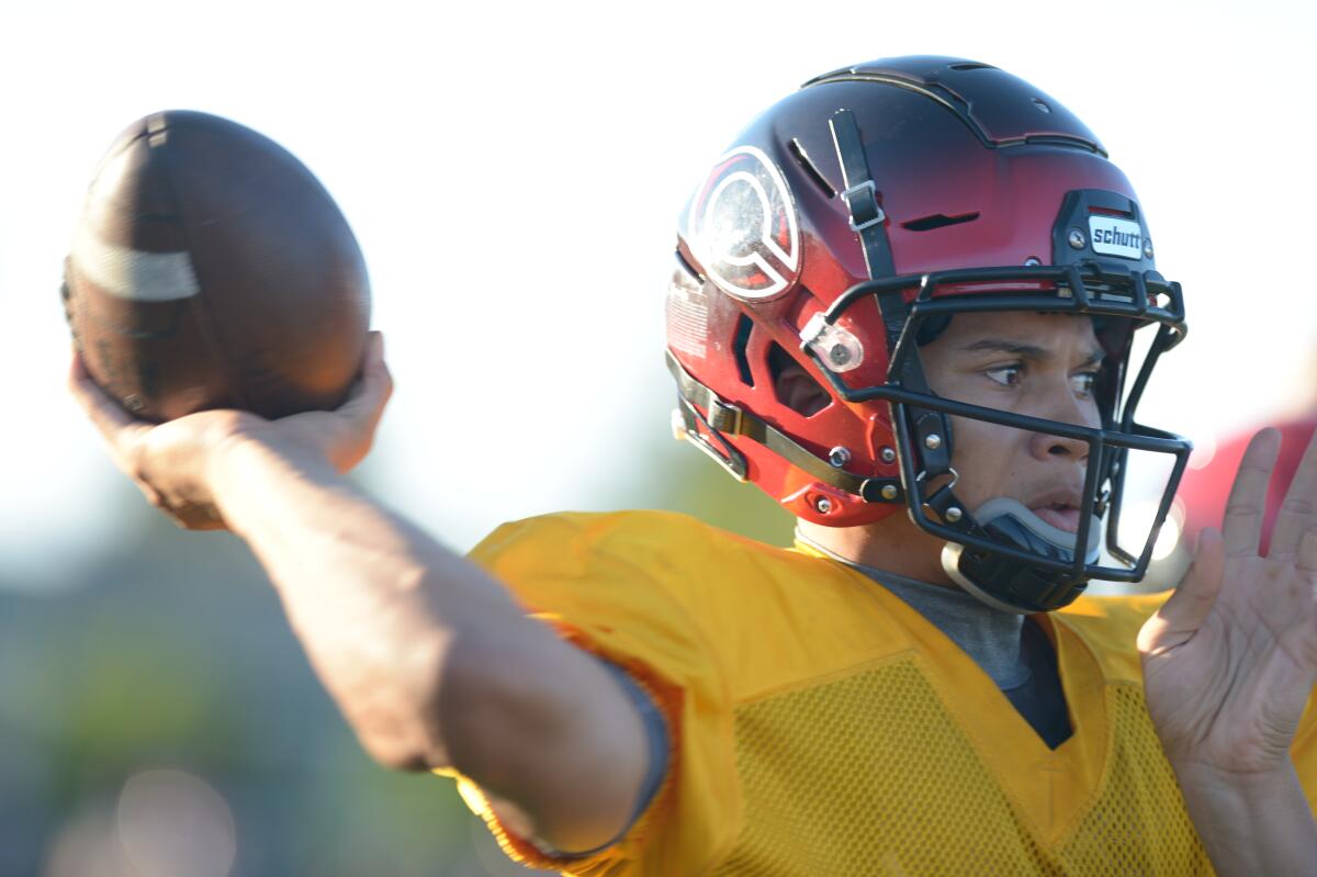 Corona Centennial quarterback Husan Longstreet throws a pass during practice.