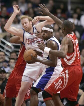 Clippers Elton Brand pulls down a rebound sandwiched between Houston Rockets Dikembe Mutombo and teammate Chris Kaman.