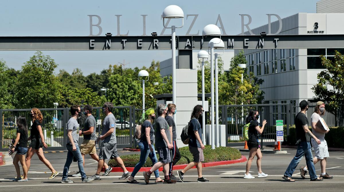 Employees pass in front of the main entrance at Activision Blizzard in Irvine in July. 