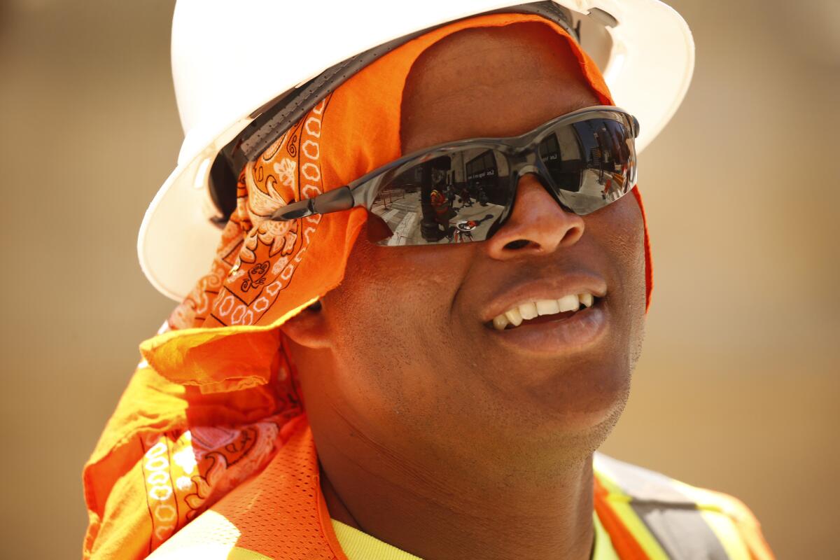 Diont Harp, a worker on a light-rail line, tries to keep cool Monday in downtown Los Angeles as a record-setting heat wave tightens its grip on the Southland.