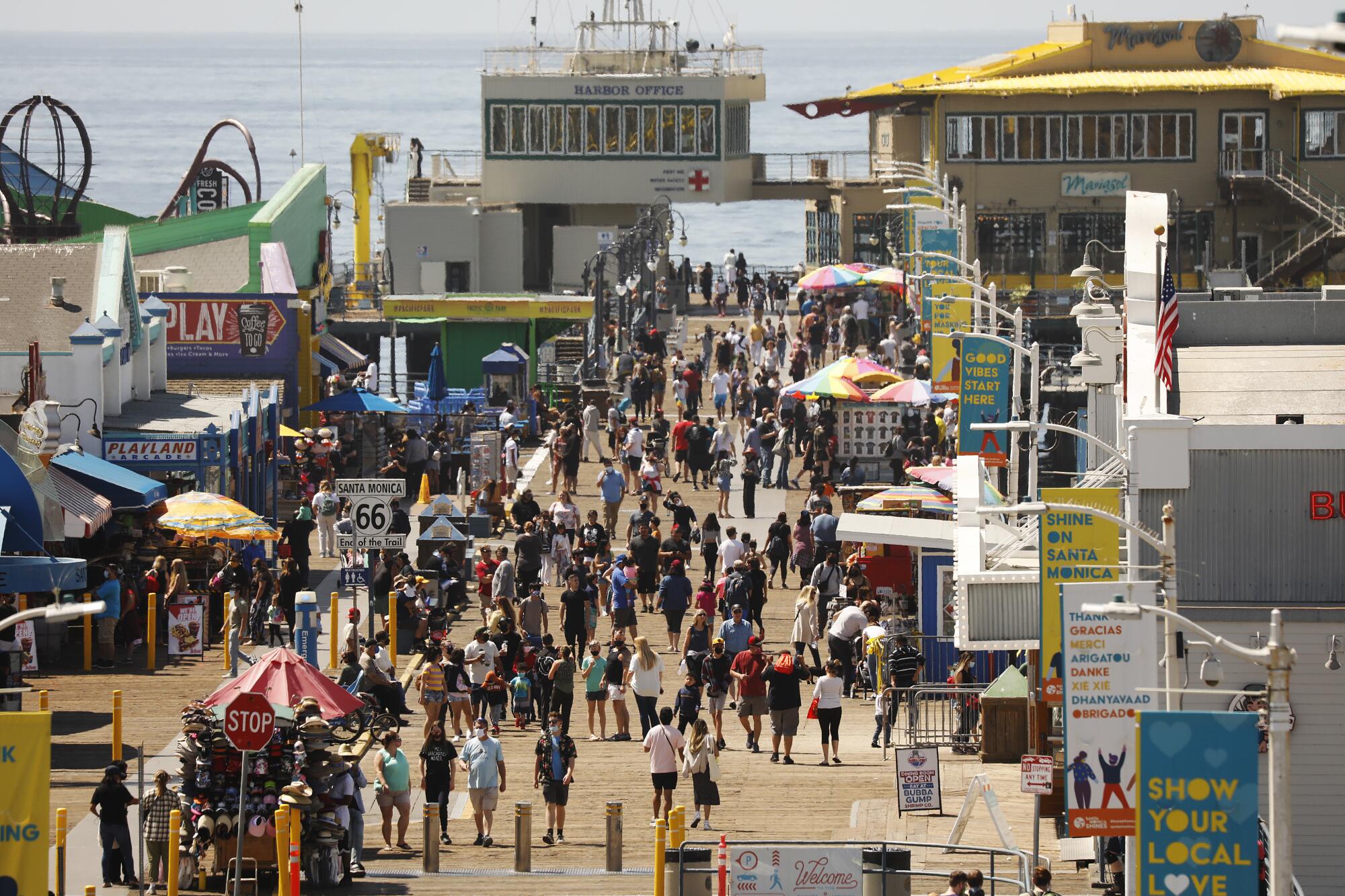 People pack a sunny pier.