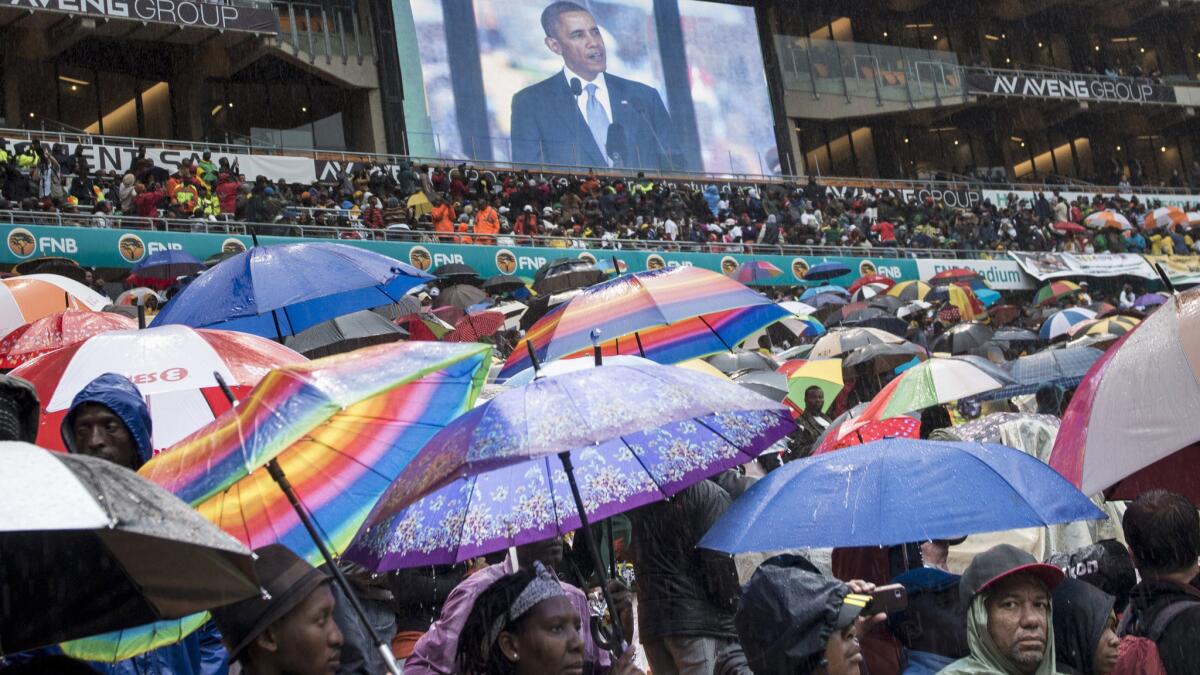 A giant screen at the Soweto soccer stadium in Johannesburg shows President Obama delivering his eulogy for former South African President Nelson Mandela.