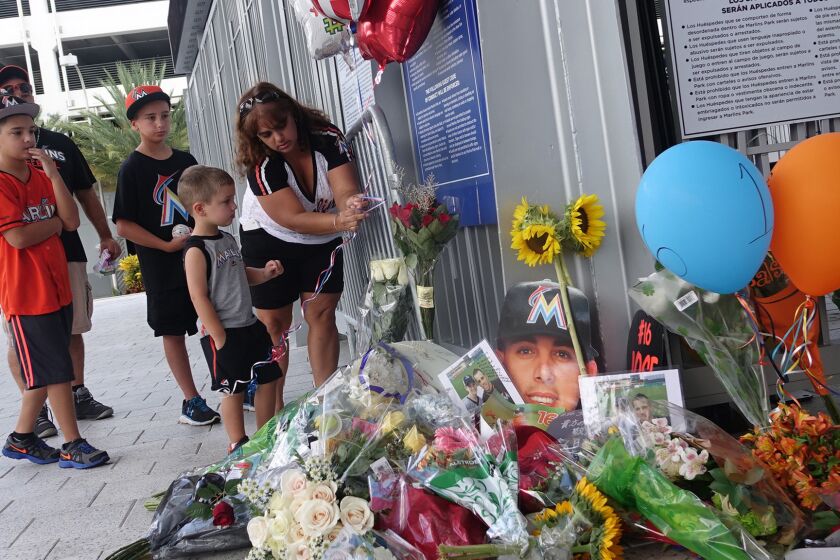 The Lopez family of Miami places balloons at a memorial in front of Marlins Park on Sunday.