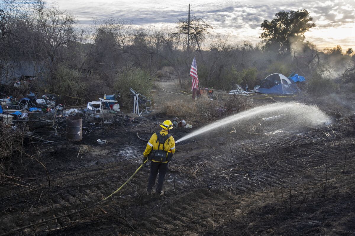 Los Angeles County firefighters put out a hot spot in the Durfee fire.