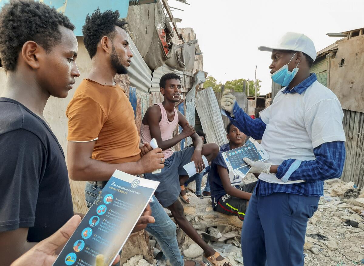 Stranded Ethiopian migrants in Bosaso, Somalia, receive brochures about the coronavirus.