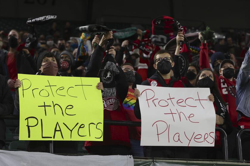 Portland Thorns fans hold signs urging NWSL leadership to "protect the players"