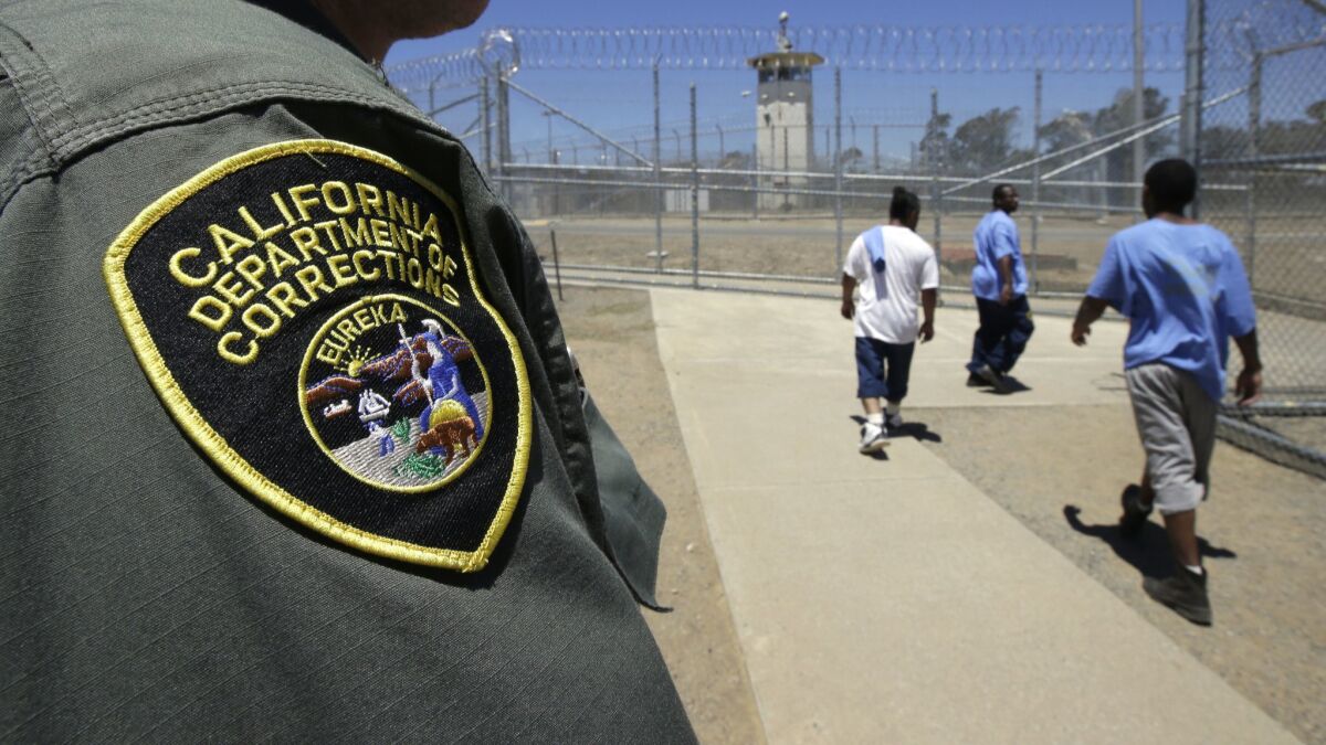 Inmates pass a correctional officer as they leave an exercise yard at the California Medical Facility in Vacaville. Last week, the California Correctional Peace Officers Assn. announced $1 million in television ads, including an effort to back Lt. Gov. Gavin Newsom for governor.