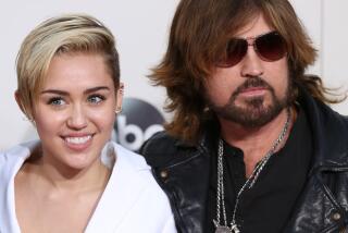 Miley Cyrus and Billy Ray Cyrus pose together at the American Music Awards in 2013