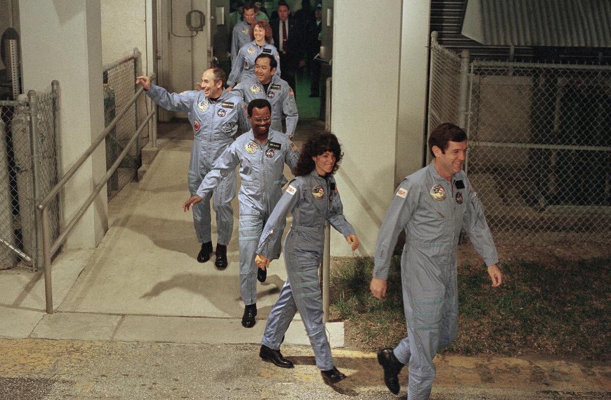 The crew for the Challenger flight leaves their quarters for the launch pad. Front to back are Commander Francis Scobee, Mission Spc. Judith Resnik, Mission Spc. Ronald McNair, Payload Spc. Gregory Jarvis, Mission Spc. Ellison Onizuka, Payload Spc. Christa McAuliffe, and pilot Michael Smith.
