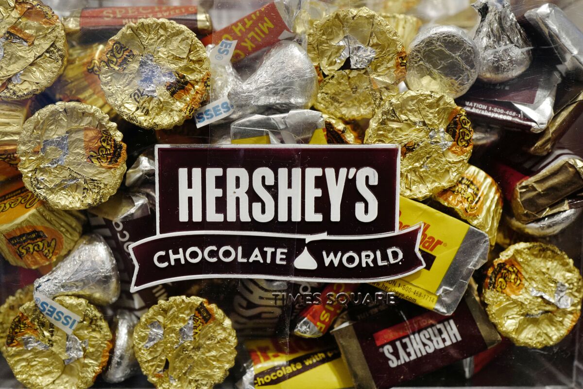 FILE - A mixture of Hershey's chocolates is displayed in the company's Times Square store, Wednesday, March 1, 2017, in New York. Hershey is expanding its salty snack portfolio with the purchase of Dot’s Homestyle Pretzels. The Hershey Co. said Wednesday, Nov. 10, 2021, that it will spend $1.2 billion for North Dakota-based Dot’s Pretzels as well as Pretzels Inc., an Indiana-based manufacturer of Dot’s Pretzels that operates three plants. (AP Photo/Mark Lennihan, File)