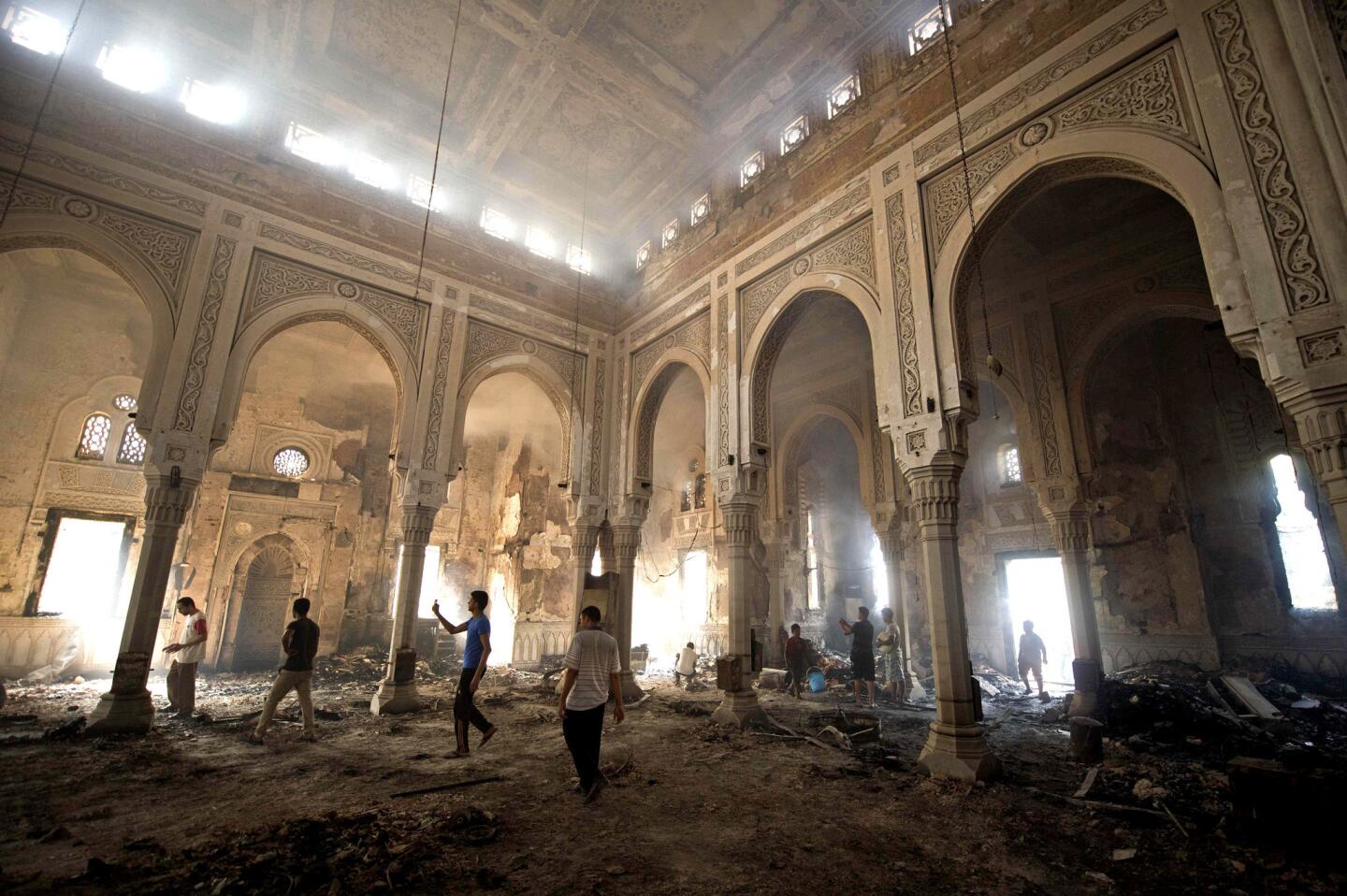 Residents survey the damage at at the burned Rabaa al Adawiya mosque in Cairo. Islamists vowed to rally later in the day in support of deposed President Mohamed Morsi despite a violent crackdown that sparked Egypt's worst day of violence in decades, with more than 500 people killed. As the death toll soared, condemnation of the previous day's crackdown on two Muslim Brotherhood protest camps in Cairo poured in.