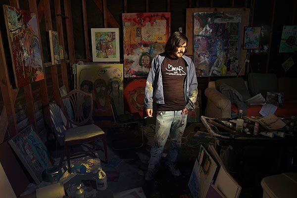 Artist Cristian Gheorghiu in his East Hollywood garage studio. Known by his street nickname of "Smear," he's facing an injunction that would bar him from profiting from art bearing his telltale graffiti "tag." See full story