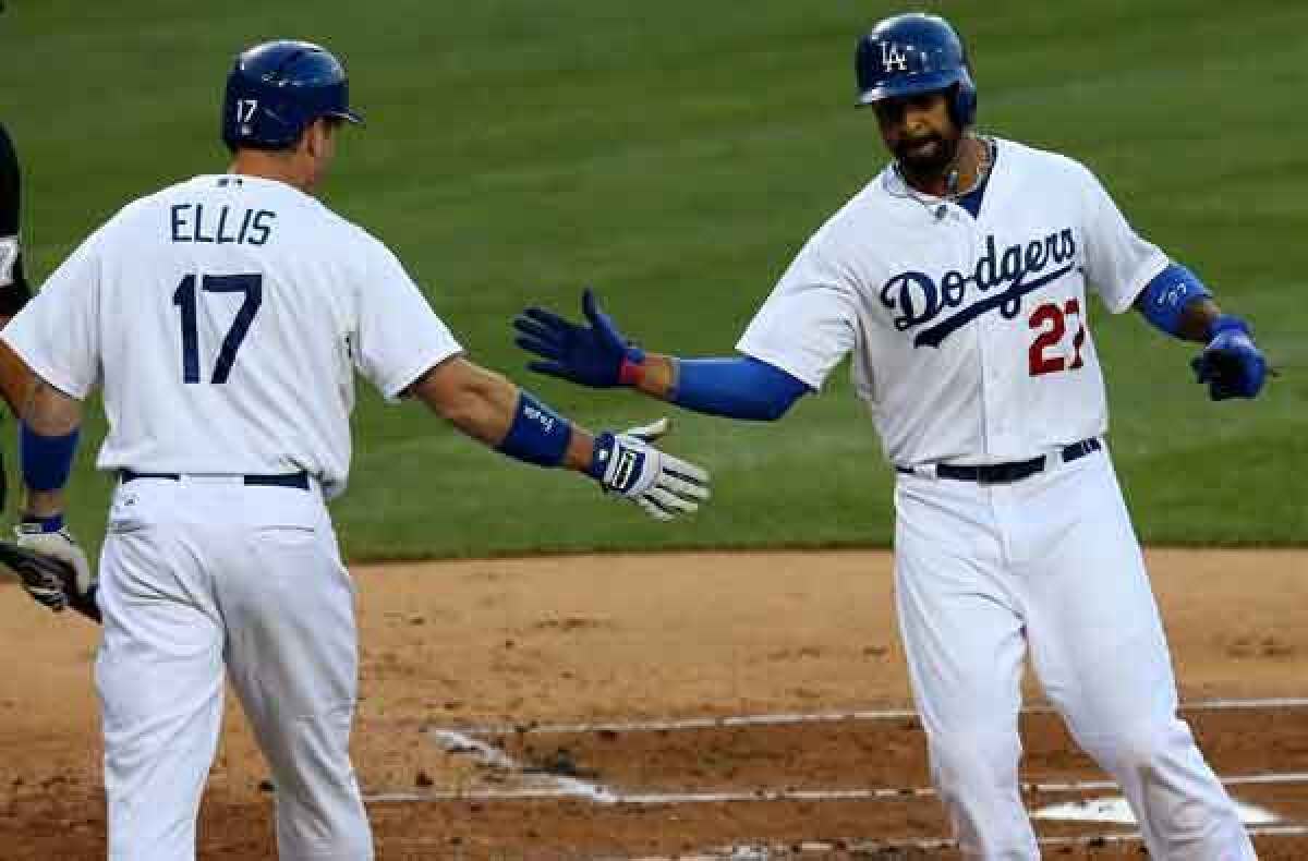 Dodgers catcher A.J. Ellis congratulates center fielder Matt Kemp after he scores in the first inning Wednesday night.